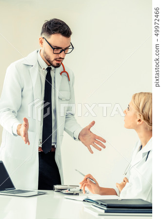 Female doctor at hospital talking to her partner. 49972466