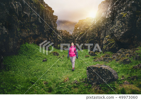Woman traveler hiking across Iceland landscape. Woman traveler hiking across Iceland landscape. 49973060