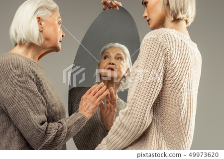 Pleasant nice elderly woman looking at herself 49973620