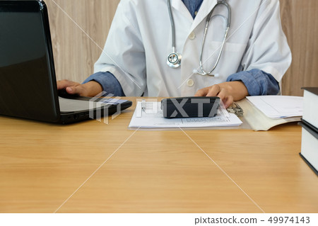 doctor physician with stethoscope calculate medical fee costs & revenue. practitioner use calculator at hospital. doctor physician with stethoscope calculate medical fee costs & revenue. practitioner use calculator at hospital. 49974143