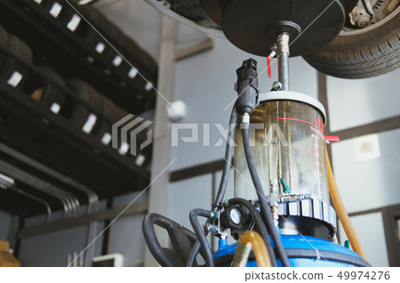 vehicle lift up by hydraulic for motor oil change & transmission inspection. changing engine oil in automobile repair service. maintenance & checkup in car workshop. vehicle lift up by hydraulic for motor oil change & transmission inspection. changing engine oil in automobile repair service. maintenance & checkup in car workshop. 49974276
