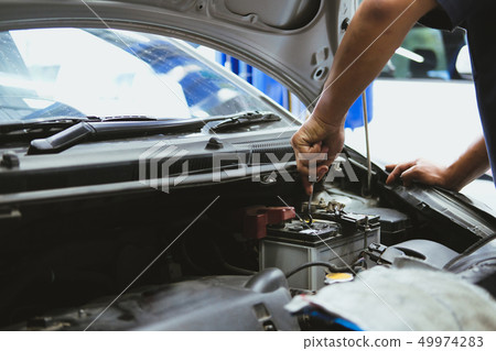 mechanic opening closing checking car battery in automobile repair service mechanic opening closing checking car battery in automobile repair service 49974283