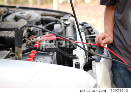 mechanic use jumper cables to charge dead car battery mechanic use jumper cables to charge dead car battery 49975240