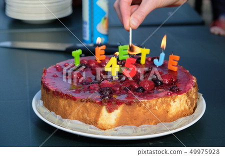 Birthday cake. Candles burn in the form of numbers 49975928