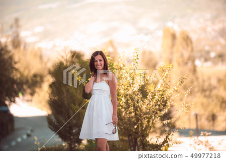 Smiling woman in white dress standing on beautiful crimea background Smiling woman in white dress standing on beautiful crimea background 49977218