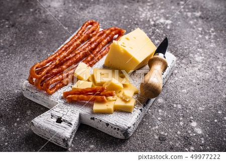 Cheese and salami sausage on wooden board Cheese and salami sausage on wooden board 49977222
