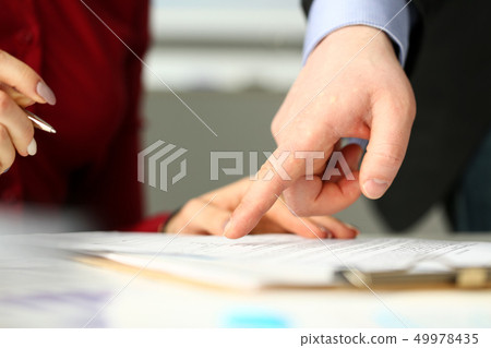 Male employee boss arm showing with finger something in document Male employee boss arm showing with finger something in document 49978435