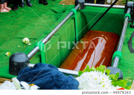 Burying a coffin at cemetery during a funeral Burying a coffin at cemetery during a funeral 49979163