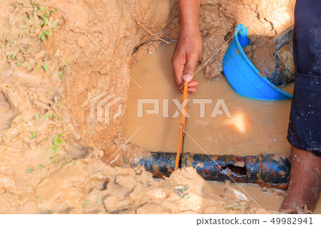 male plumber are repair broken pipe in hole 49982941