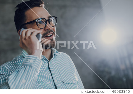 Happy young man is speaking on cell phone 49983540