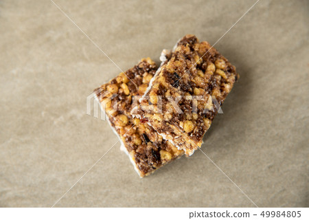 Muesli and cereal bar on marble stone background 49984805