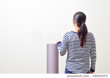 DIY woman putting a wallpaper 49985059