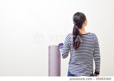 DIY woman putting a wallpaper 49985060