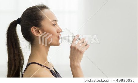 Healthcare. Girl drinking clean mineral water, side view 49986053