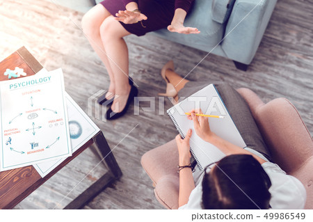 Above close-up shot of female psychologist making notes Above close-up shot of female psychologist making notes 49986549