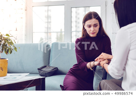 Crying lady being comforted during a visit to a psychologist Crying lady being comforted during a visit to a psychologist 49986574
