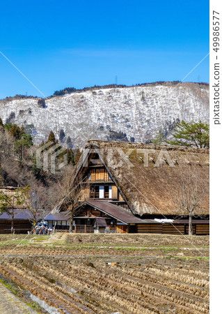 白雪皚皚的山脈和世界遺產白川鄉的城市景觀 白雪皚皚的山脈和世界遺產白川鄉的城市景觀 49986577