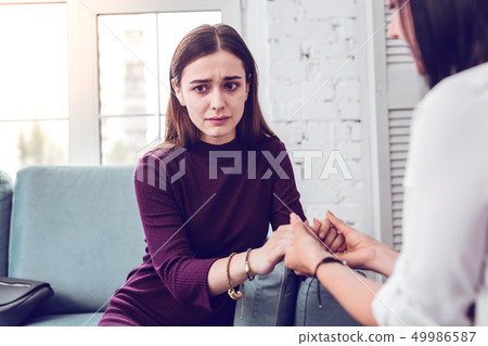 Upset crying scared attractive lady being comforted by a therapist Upset crying scared attractive lady being comforted by a therapist 49986587