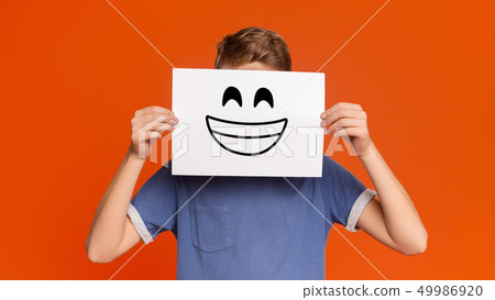 Teenage boy holding paper with smiley face 49986920