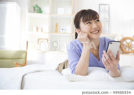 A woman operating a smartphone A woman operating a smartphone 49986934