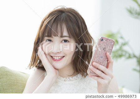 A woman watching a smartphone 49986973