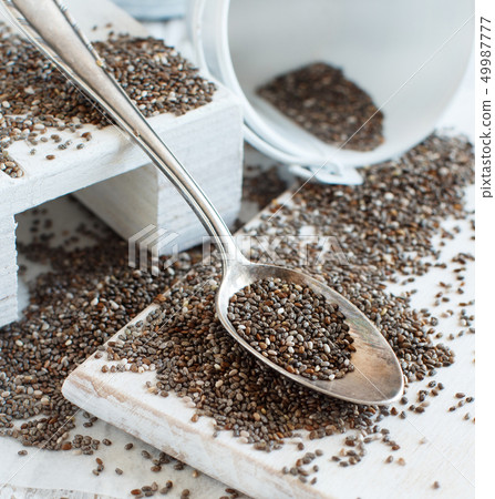 Chia seeds with a wooden spoon Chia seeds with a wooden spoon 49987777