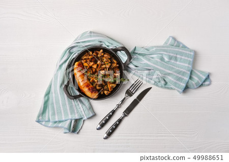 Cast-iron pan with fried sausage and mushrooms Cast-iron pan with fried sausage and mushrooms 49988651