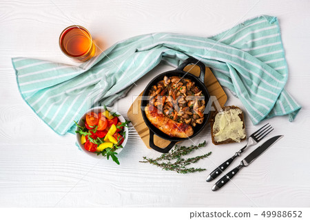 Cast-iron pan with fried sausage and mushrooms Cast-iron pan with fried sausage and mushrooms 49988652