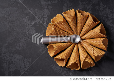 Waffle cones for ice cream and a spoon for it on Waffle cones for ice cream and a spoon for it on 49988796