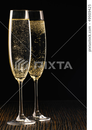 Two glasses of sparkling wine, close up. Black Two glasses of sparkling wine, close up. Black 49989425