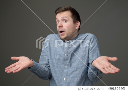 guy showing I have no idea gesture, shrugging shoulders and raising hands 49989695