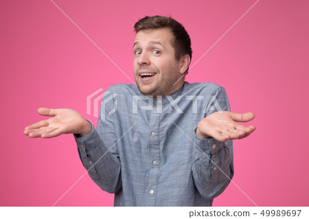 guy showing I have no idea gesture, shrugging shoulders and raising hands 49989697