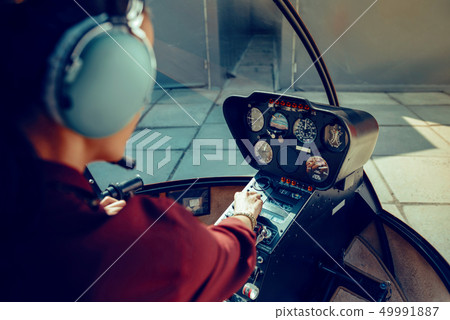 Resolute experienced female pilot observing information on dashboard 49991887