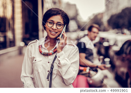 Positive dark haired woman putting her phone to the ear Positive dark haired woman putting her phone to the ear 49991901