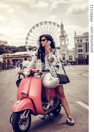 Beautiful young woman putting a phone to her ear 49992312