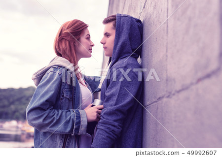 Resolute long-haired ginger girl attentively looking on her boyfriend 49992607