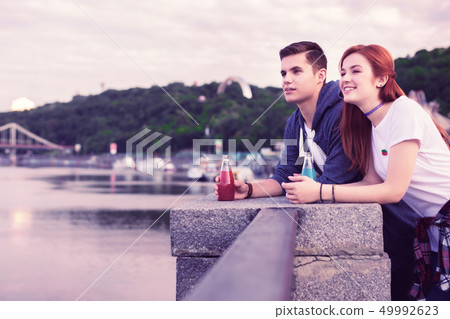Inspired dark-haired guy looking on the river view while staying with girl 49992623