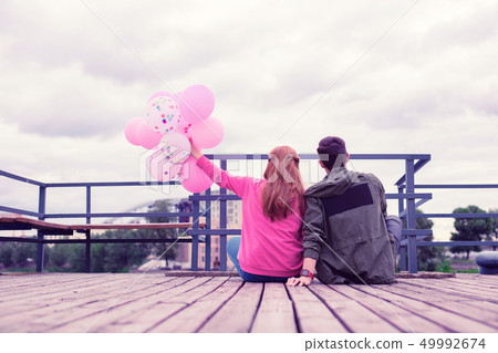Lovely good-looking young couple spending time together on the wooden pier 49992674