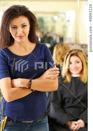 Portrait of beautiful smiling brunette hairdresser Portrait of beautiful smiling brunette hairdresser 49993129