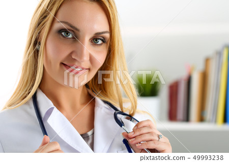 Beautiful smiling female doctor stand in office Beautiful smiling female doctor stand in office 49993238