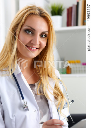 Beautiful smiling female doctor hold clipboard pad Beautiful smiling female doctor hold clipboard pad 49993267