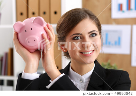 Happy beautiful woman shaking funny piggybank Happy beautiful woman shaking funny piggybank 49993842