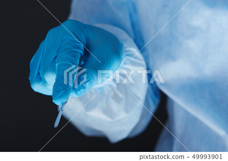 Surgeon hand holding surgical scalpel Surgeon hand holding surgical scalpel 49993901