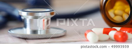 Medical stethoscope head lying on cardiogram chart Medical stethoscope head lying on cardiogram chart 49993939