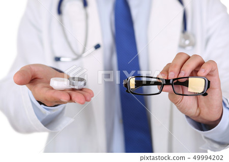 Male doctor hands giving pair of black glasses and contact lens 49994202