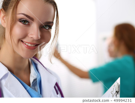 Beautiful smiling female medicine doctor looking in camera Beautiful smiling female medicine doctor looking in camera 49994231