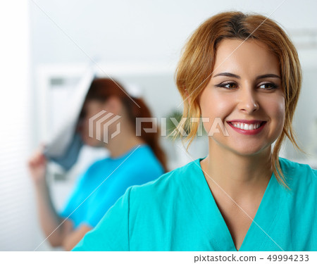 Beautiful female medicine doctor laughing on her colleague Beautiful female medicine doctor laughing on her colleague 49994233