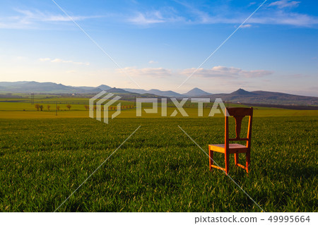 Sunset with old chair in the spring field in Sunset with old chair in the spring field in 49995664