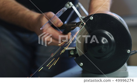 Master works behind grinding machine. 49996274