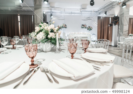 Interior of restaurant for wedding dinner, ready for guests. Round Banquet table served. Decorated 49998124
